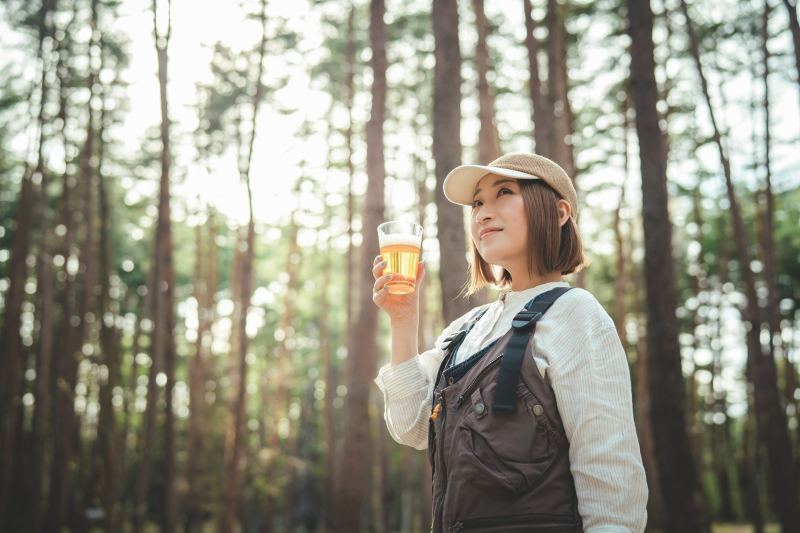 山の中でビールを飲む女性